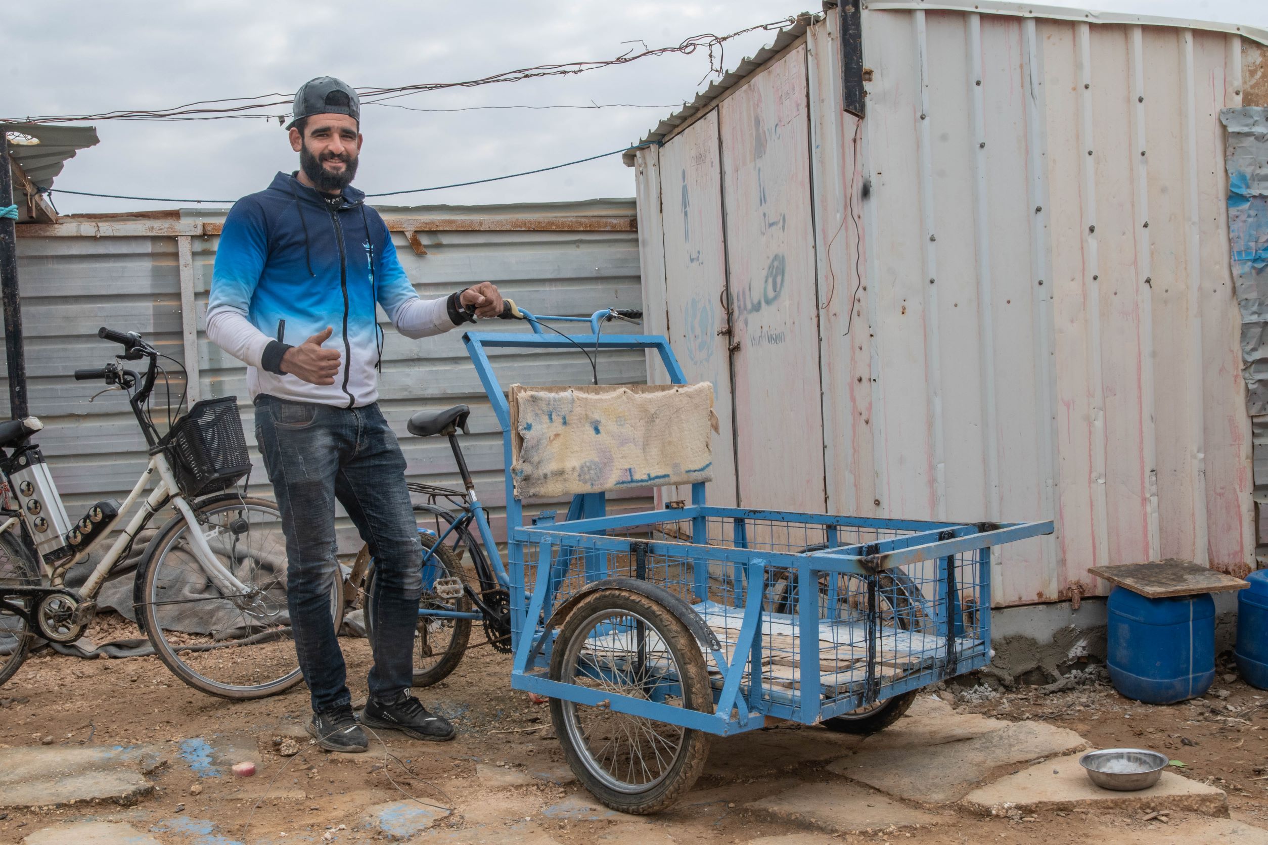 Aqil built this cart to help his neighbours carry gallons of water. Some places, like the community centres, have running water, but most people have to transport gallons of water from a well to their shelters. Aqil is deaf and communicates mostly with hand gestures. Some neighbours learned sign language to communicate with him.