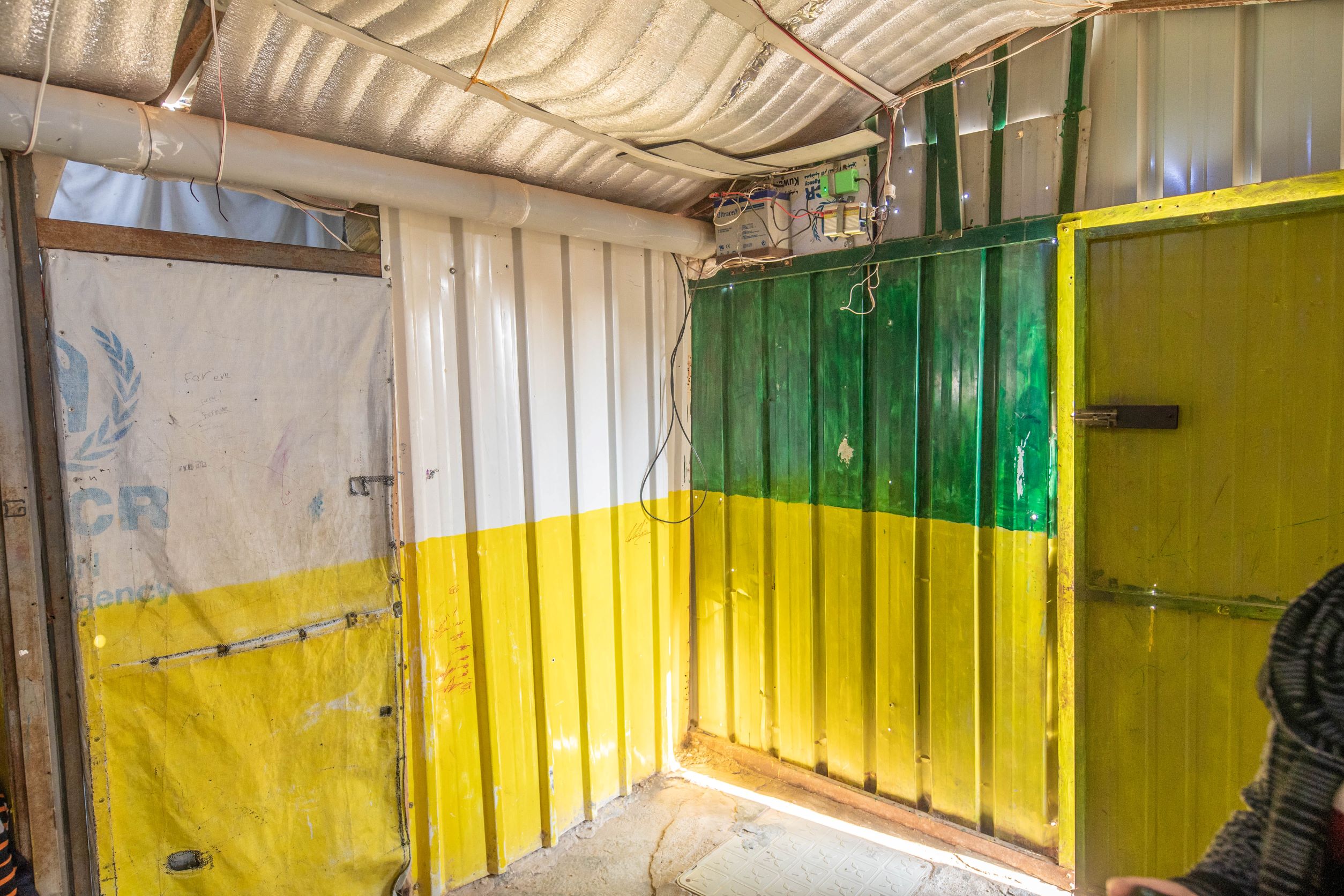 Innovation-EmergencyPowerSupply_1_7310_kll Nuha ist 17 und hat dieses Notstromaggregat im Rahmen eines Projekts im Camp gebaut. Die notwendige Batterie, die man in der Ecke über der grünen Farbe sehen kann, wurde von einer NGO gespendet. Wenn der Strom im Lager unterbrochen ist, können Nuha und ihre Familie, Freunde und Nachbarn diesen kleinen Notstromgenerator verwenden, um die Handys aufzuladen oder das Licht zum Lernen zu verwenden.